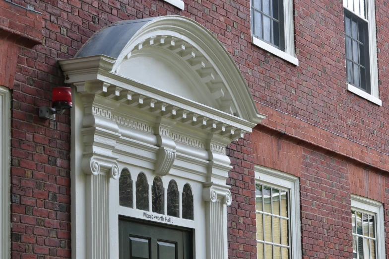 an open white door sits on the side of a brick building