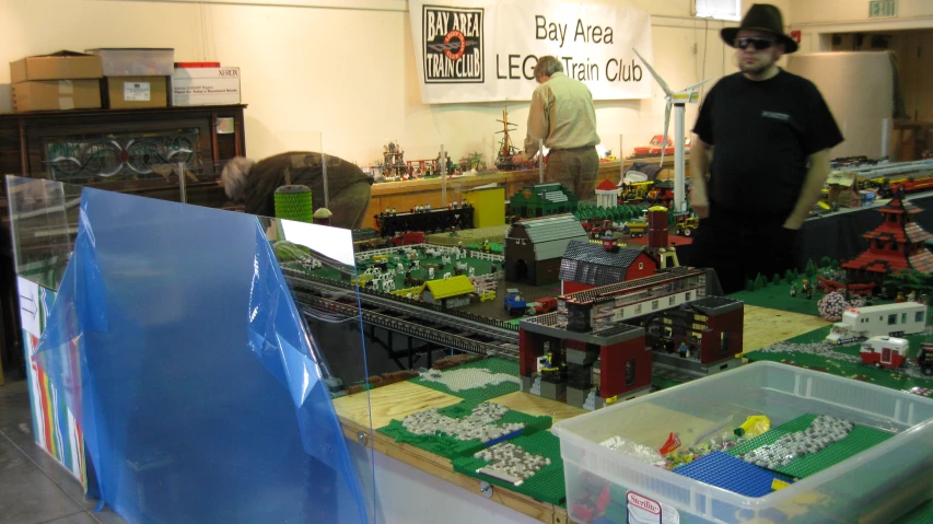 some men standing around with large display of legos and buildings