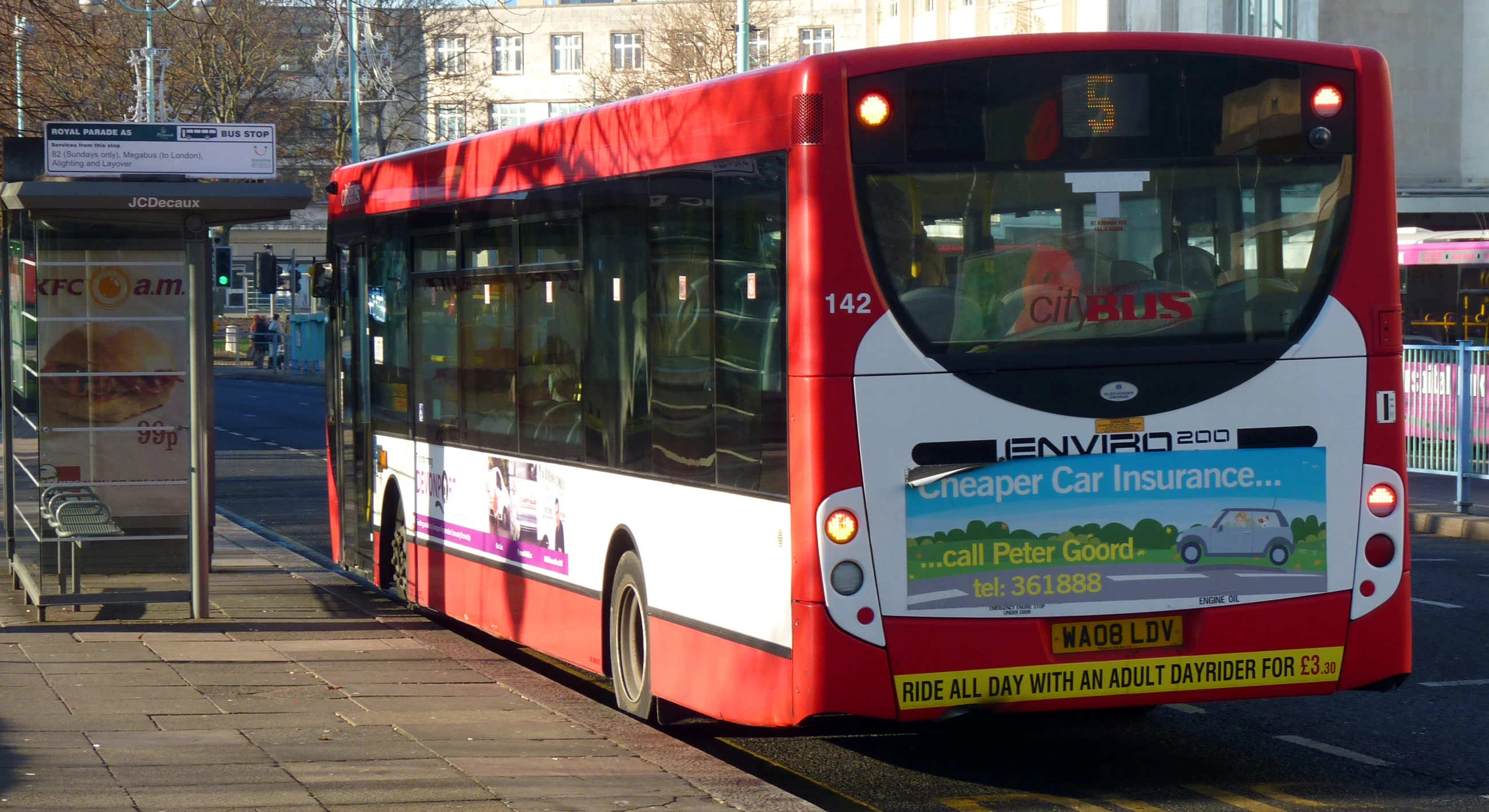 a double decker bus stops on the side of the street