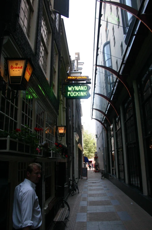 a narrow city street is lined with shops