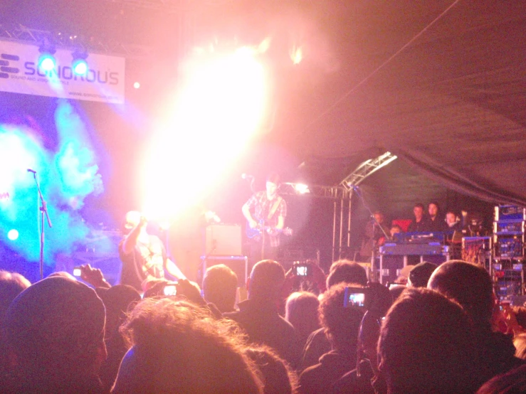 a large crowd of people at a concert with bright lights