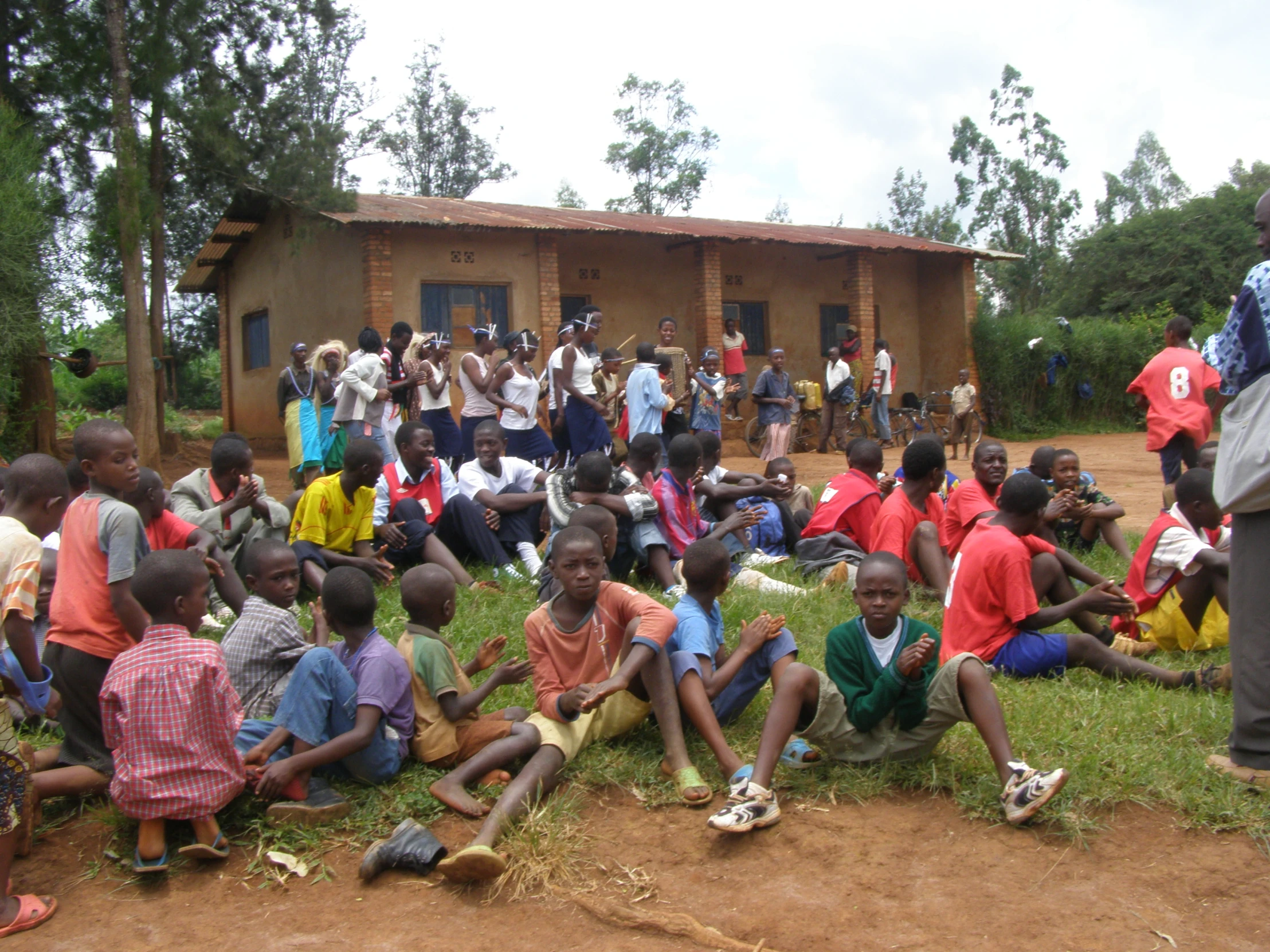 people gathered around a small group with a building in the background