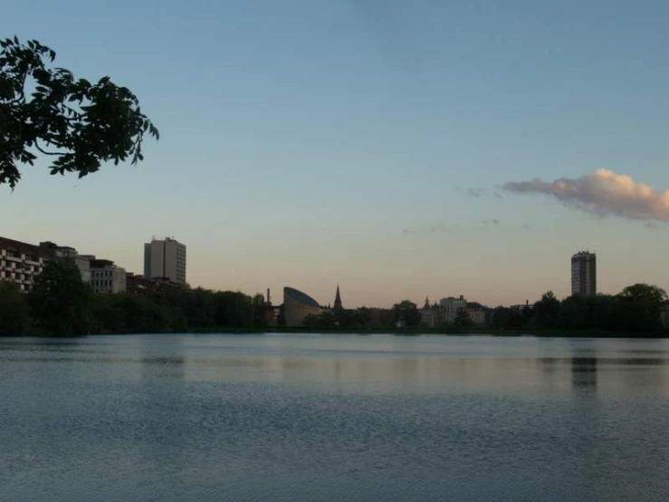 a lake with buildings on it under a blue sky