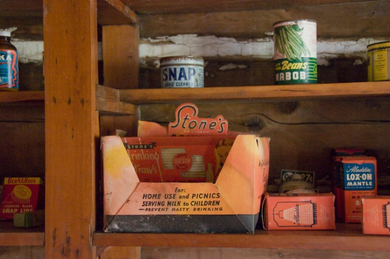 antique boxes, tins and cans on display in wood shelves