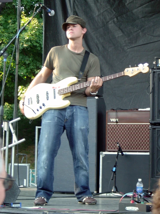 a man with glasses and a guitar standing on a stage
