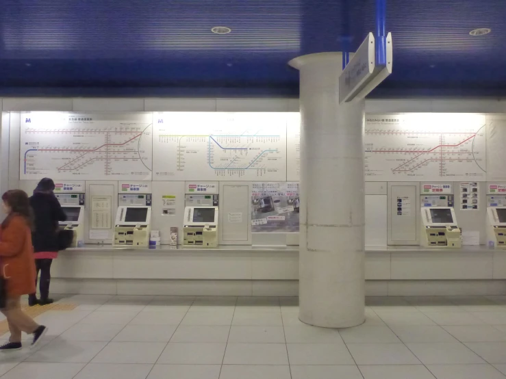 people are standing around using telephones to use a public phone