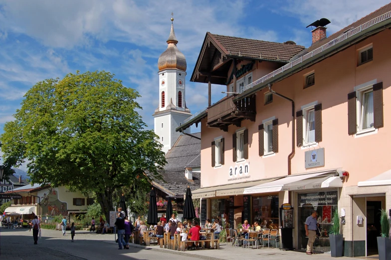 many people are outside of a building in a town