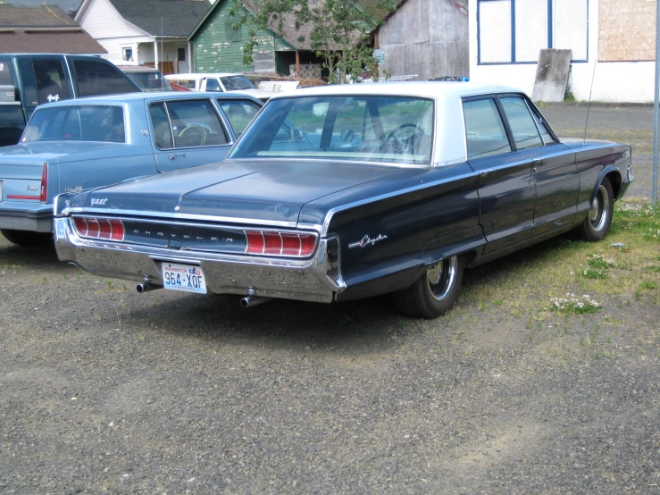 old black car parked in parking lot by a house