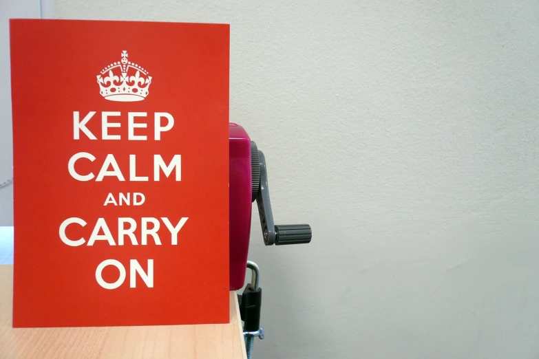 a red sign that reads keep calm and carry on