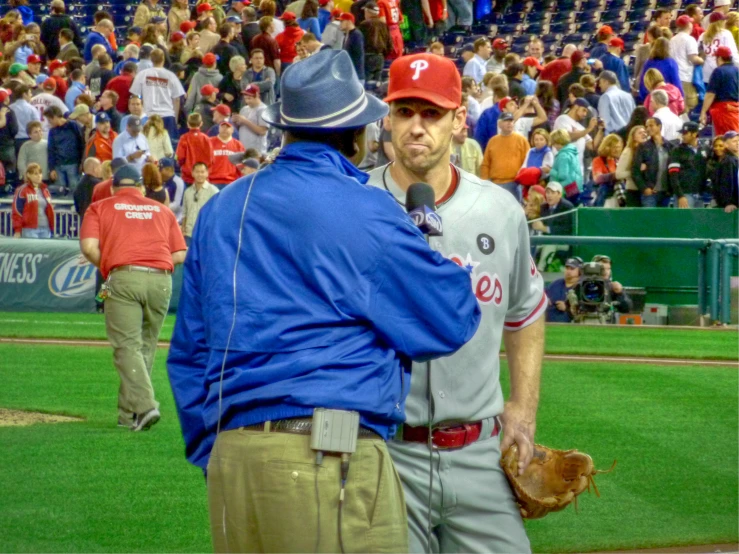 two baseball players are talking to each other in the stands