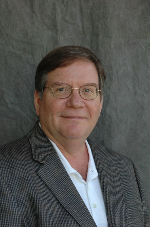 a man in glasses and a gray suit