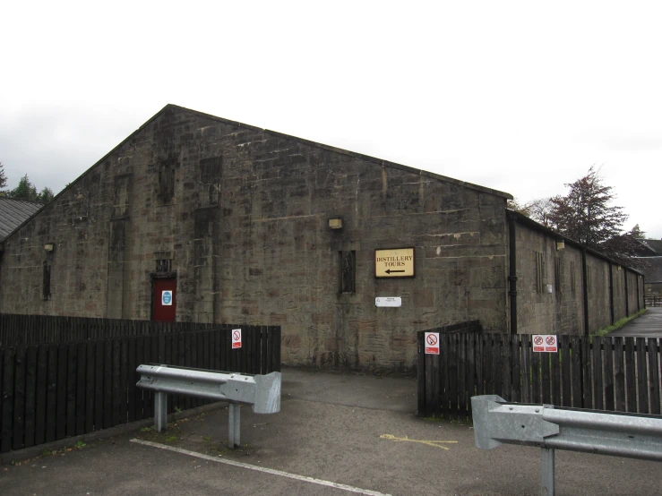 the building is made of dark bricks and has two benches