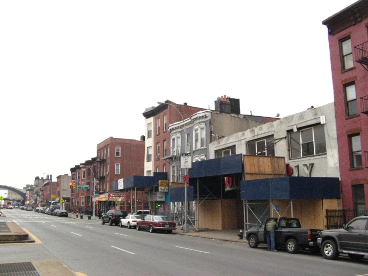 some cars are parked on the street in front of buildings