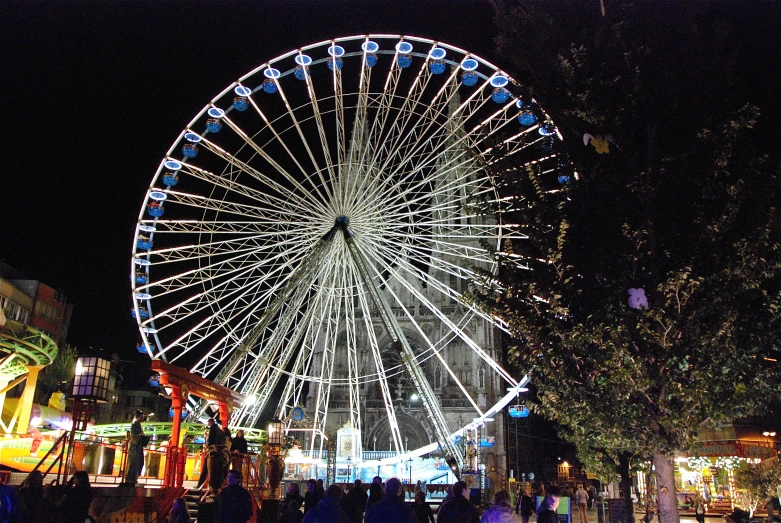 the illuminated ferris wheel is in the night city