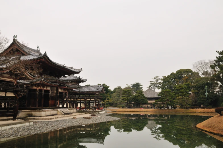 the exterior view of a chinese styled house by the pond