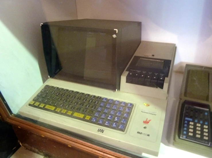 some old computer monitors and calculator on a desk