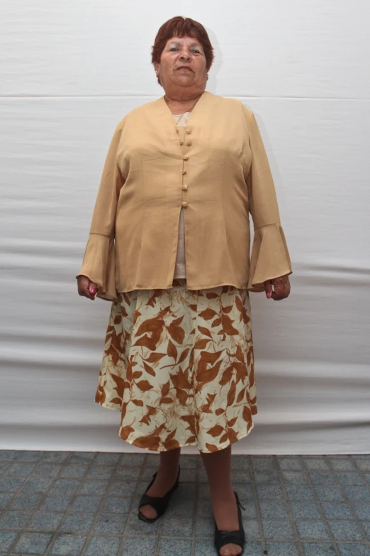 a woman in a skirt and cardigan poses for a picture