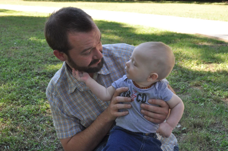 a man with beard is playing with a small child