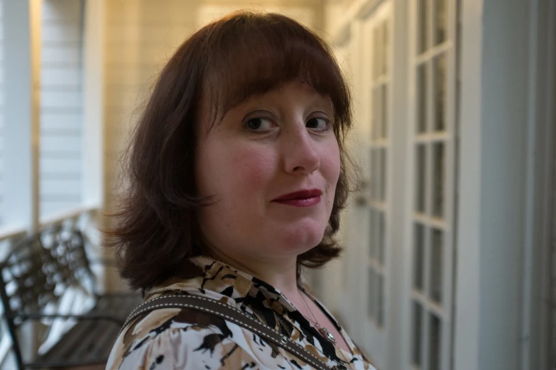 a woman standing outside on the porch next to a porch