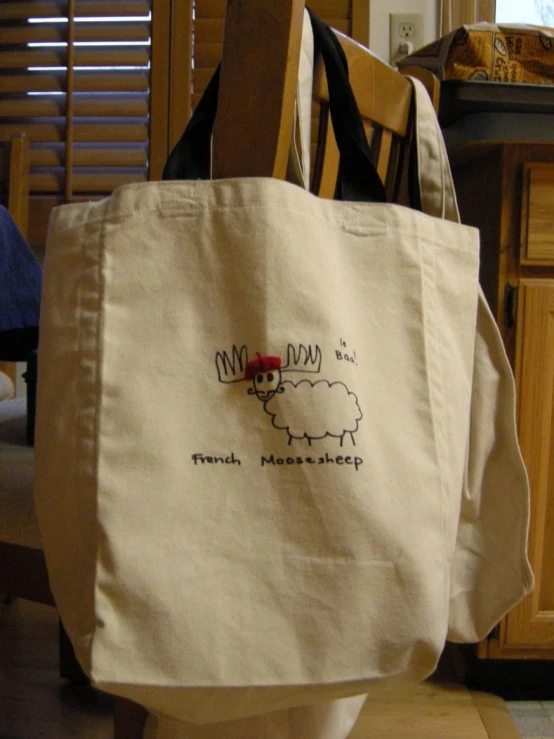 a small, beige shopping bag with an embroidered sheep