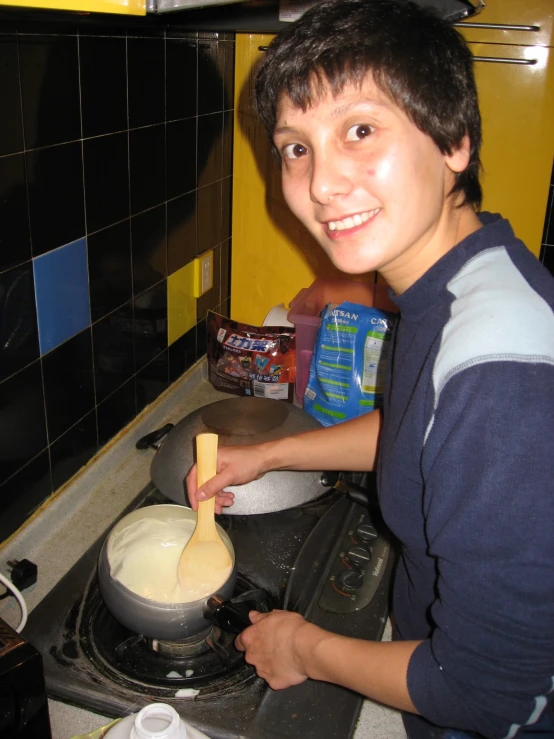 a man stands on the stove stirring soing