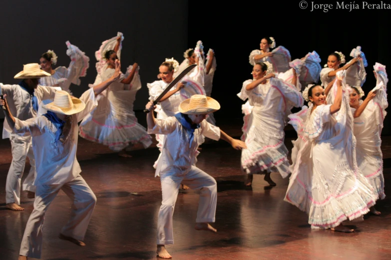 an artistic performance of dancers in white outfits