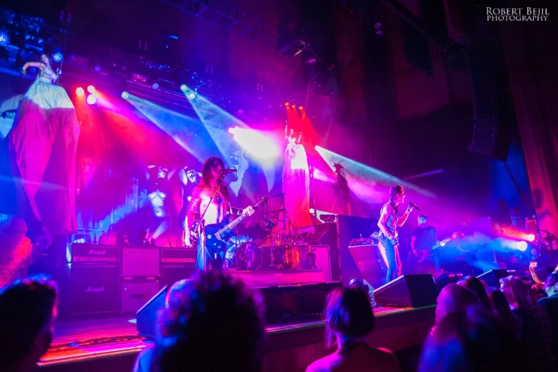 a group of people in a concert with bright lights