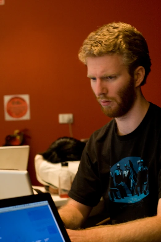 man sitting at desk working on his laptop