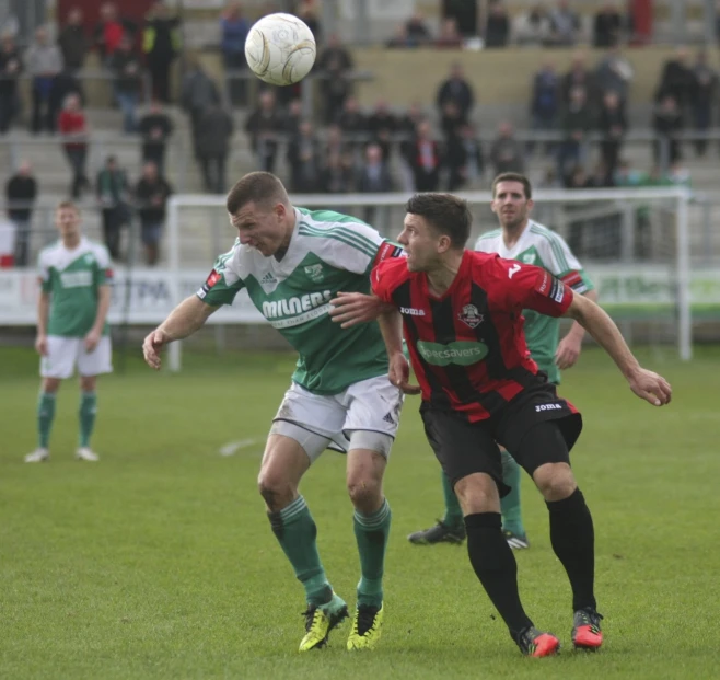 two soccer players fighting for the ball during a game