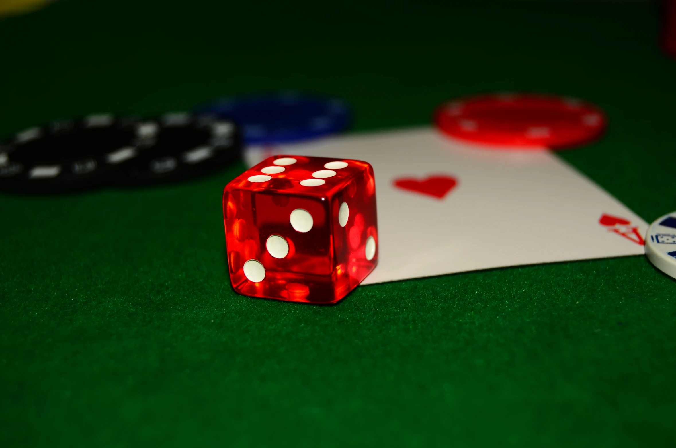 a dice and poker chips sit next to a white sheet