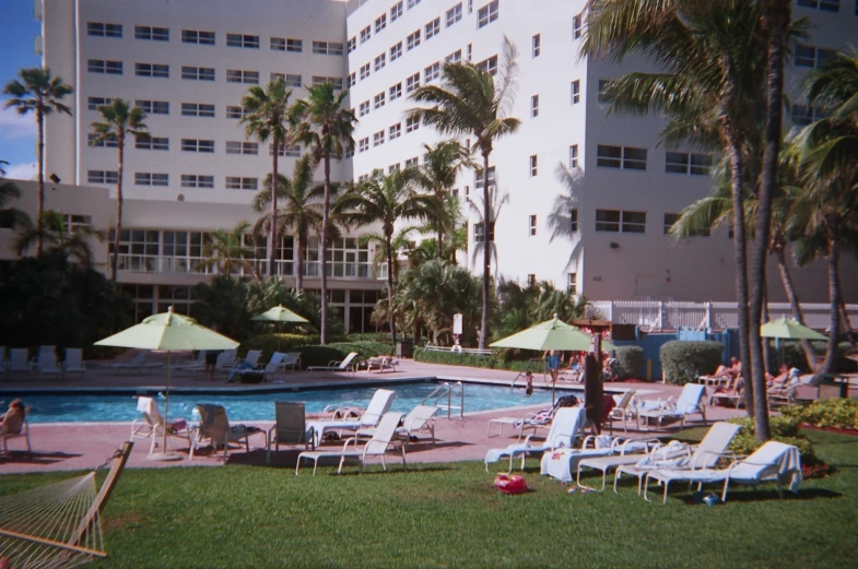 a el with pools and lawn chairs is in front of it