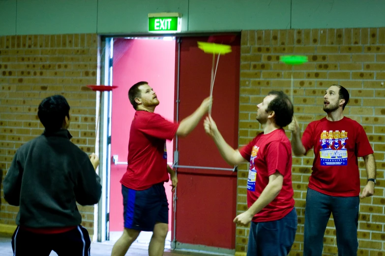 a group of men standing around a door playing frisbee