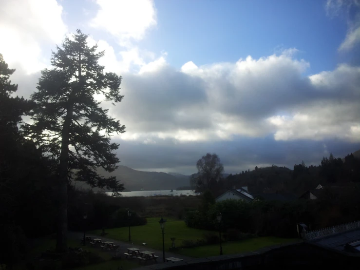 there are clouds flying above the trees at the park