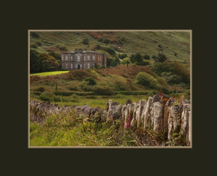 an old house sitting on top of a lush green hill