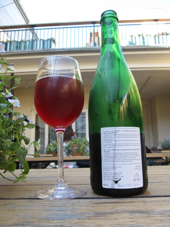 a green and a brown bottle and wine glass