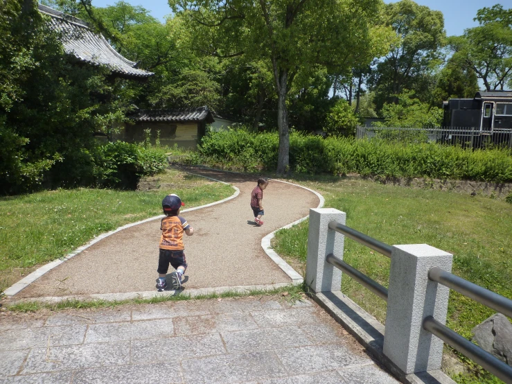 two young children playing on their skateboards on a path