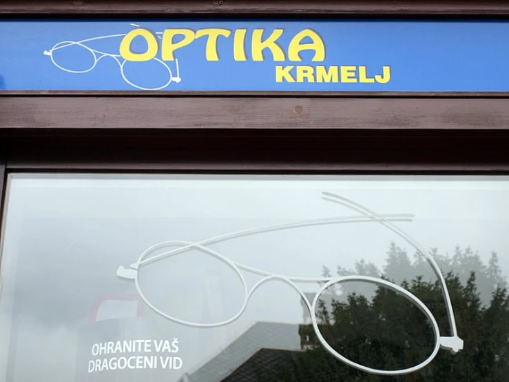 an old fashioned pair of white glasses is mounted on the side of a store