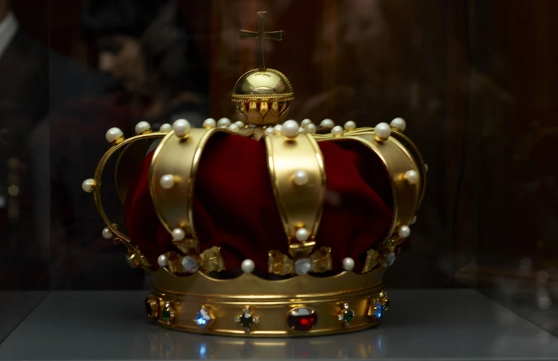 a red and gold crown sitting on top of a white counter