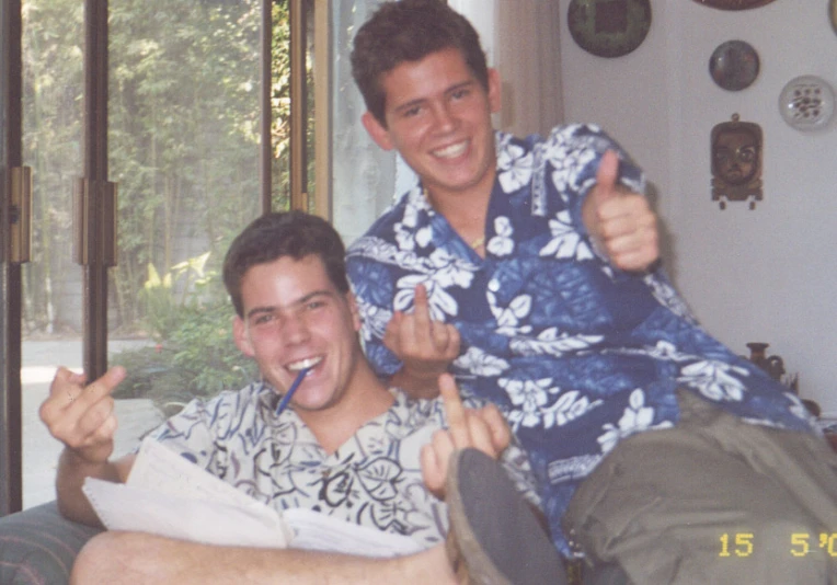 a man giving the thumbs up while sitting next to another man