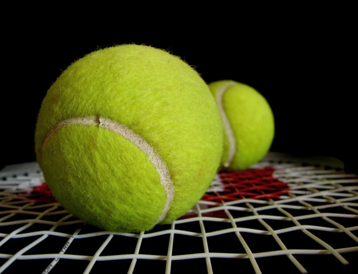 there are three tennis balls with stitches on the side of the racket