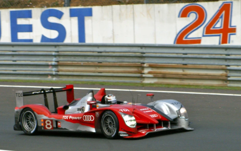 a race car driving around a turn at an event