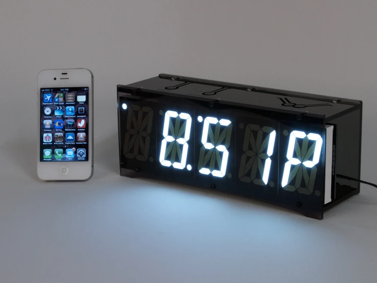 a clock on the table next to an iphone