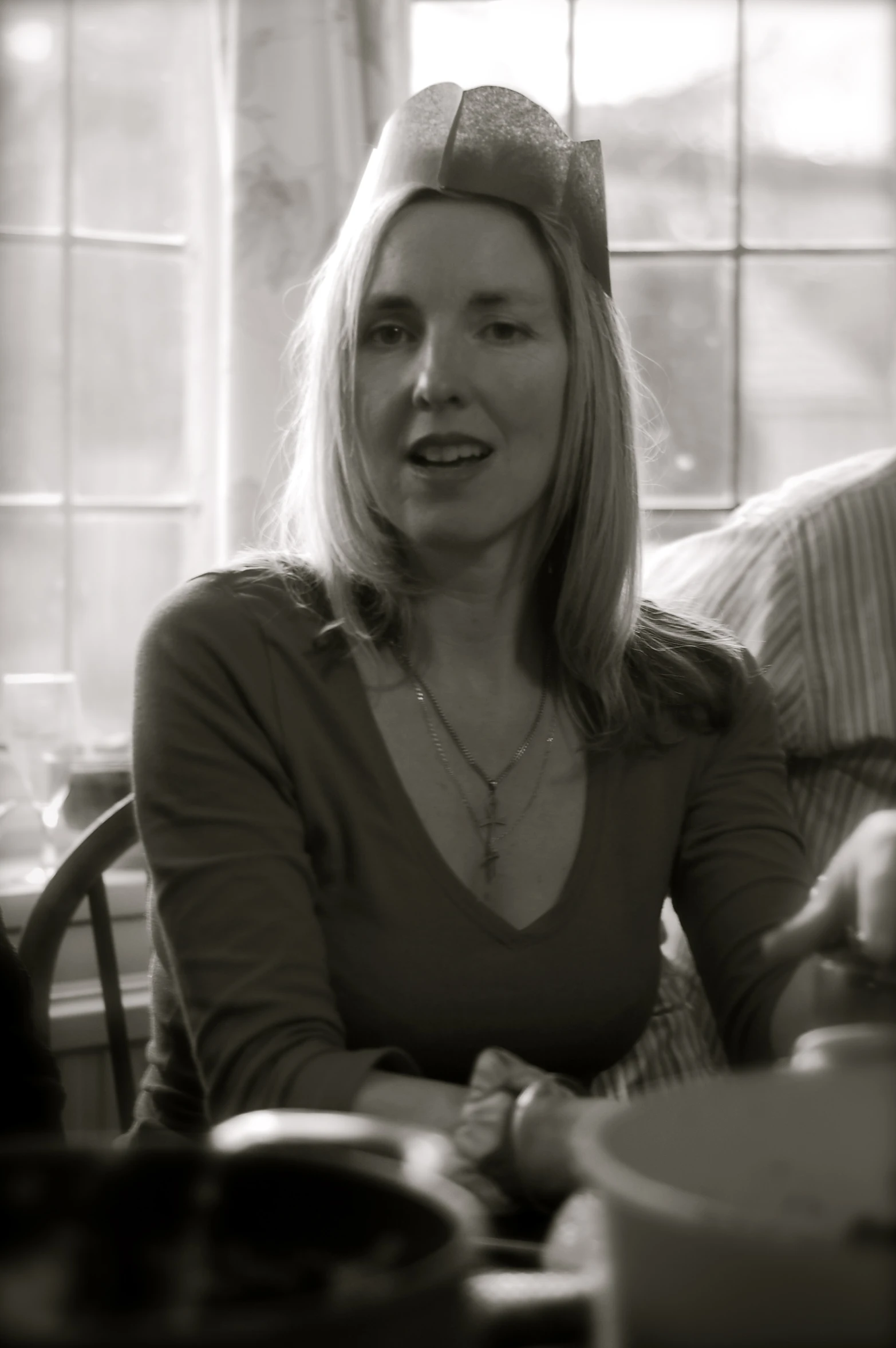 a woman smiles as she sits at a table