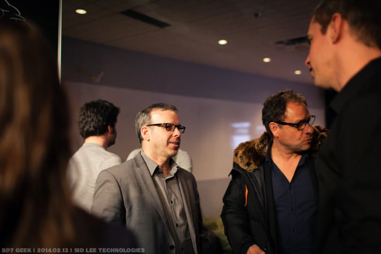 three men standing and talking next to each other