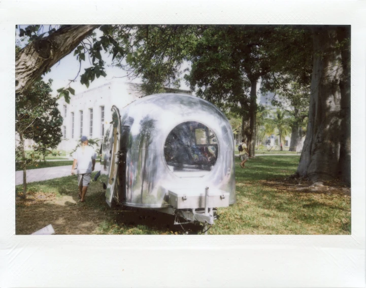 an old po of a silver colored trailer parked in front of a large white building