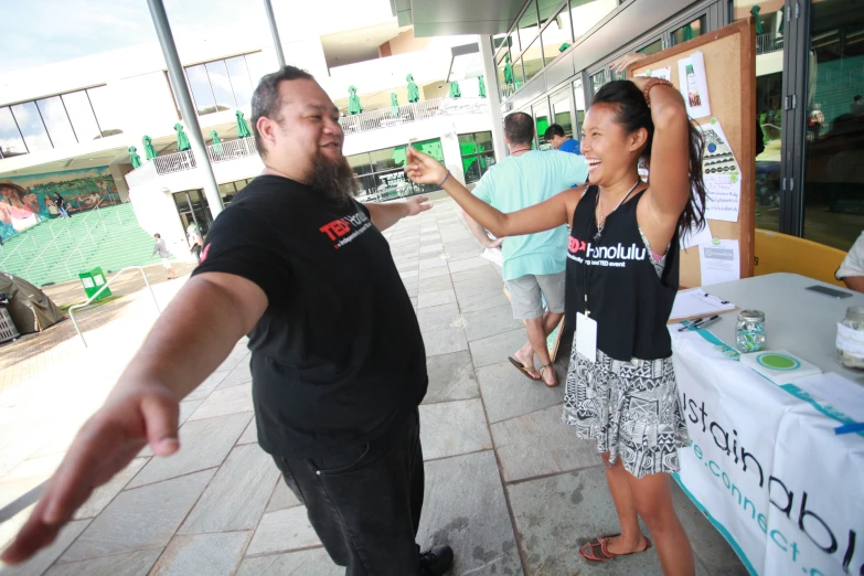 a man standing next to a woman near a table