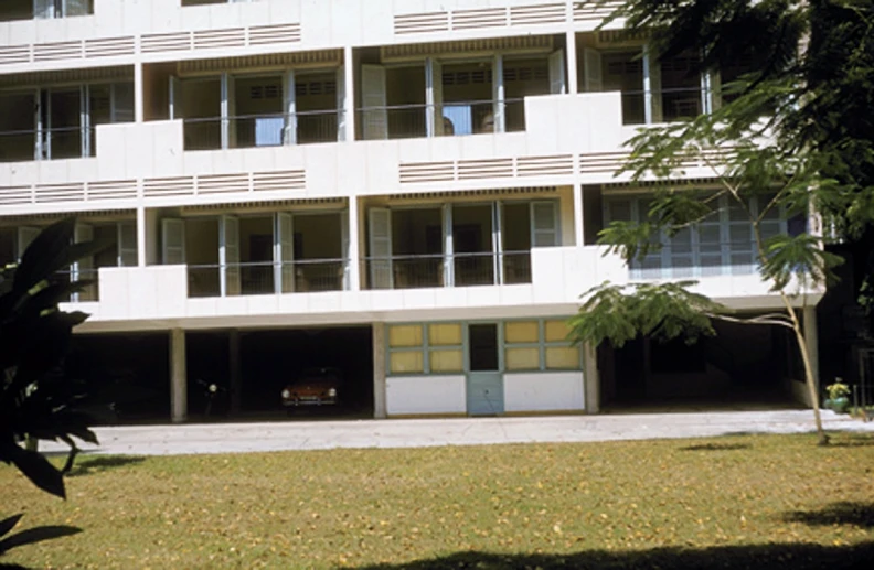 a white building with balconies and an open gate