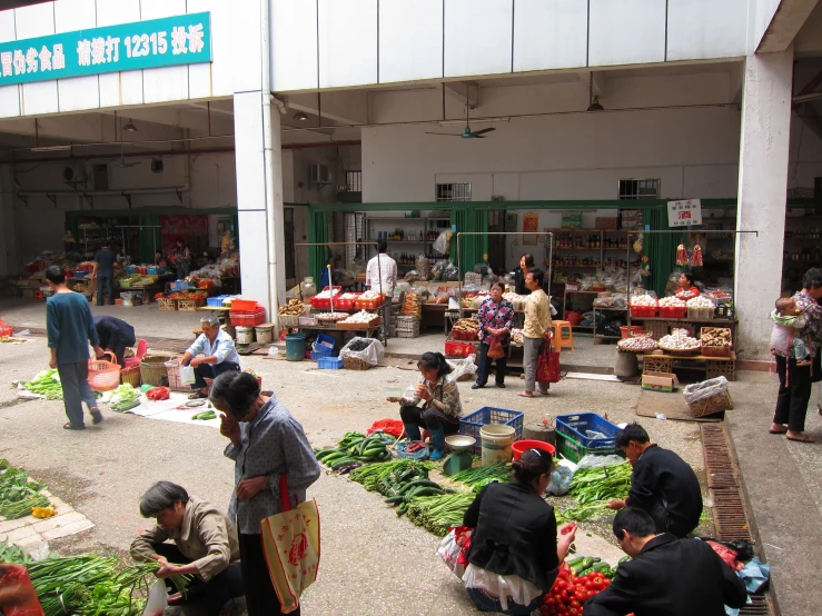 a market is selling vegetables and fruits and people are shopping