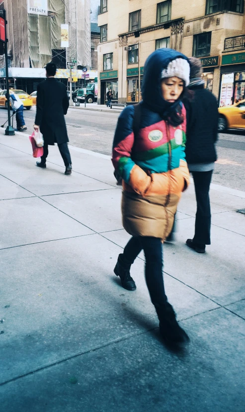 the young woman is walking down the sidewalk