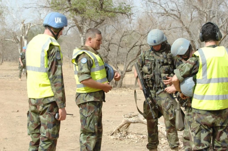 some soldiers are talking to other men in uniforms